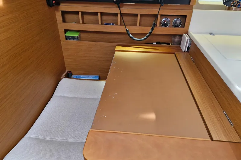 Dreamcatcher II Yacht Photos Pics Interior of 2019 Jeanneau Sun Odyssey 440, featuring a wooden navigation desk and seating area.