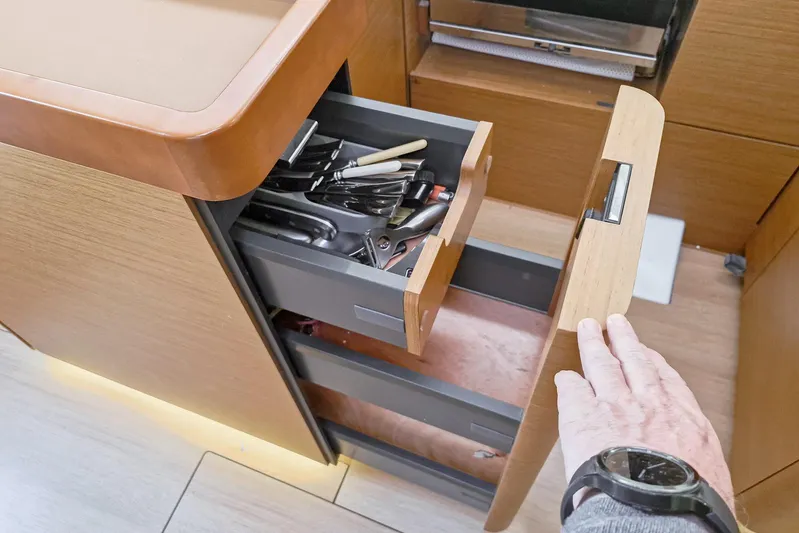 Dreamcatcher II Yacht Photos Pics Open drawer in Jeanneau Sun Odyssey 440 yacht kitchen, showcasing utensils and storage.