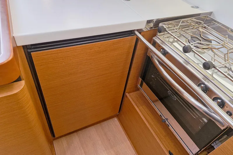 Dreamcatcher II Yacht Photos Pics Jeanneau Sun Odyssey 440 2019 yacht kitchen with stove and wooden cabinetry.