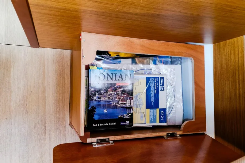Dreamcatcher II Yacht Photos Pics Storage compartment in 2019 Jeanneau Sun Odyssey 440 with nautical maps and guides.