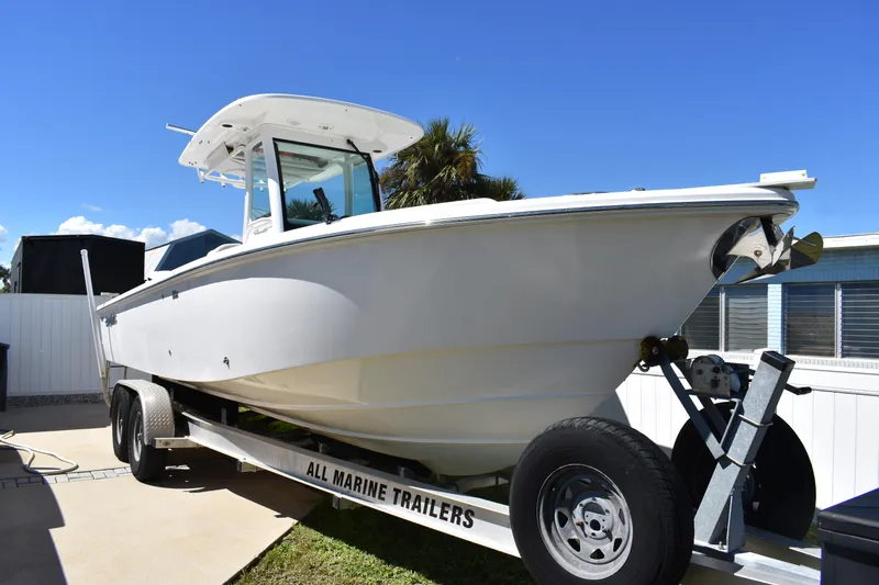  Yacht Photos Pics 2018 Everglades 273 Center Console boat on trailer, parked outdoors under clear blue sky.