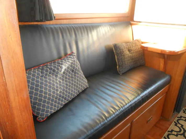 Ahoy Vey Yacht Photos Pics 1978 CHB 34 Aft Cabin interior with black leather seating and decorative pillows.