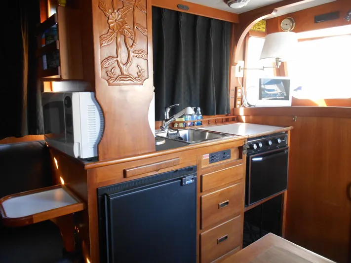 Ahoy Vey Yacht Photos Pics 1978 CHB 34 Aft Cabin kitchen with wood cabinetry, sink, stove, and microwave.