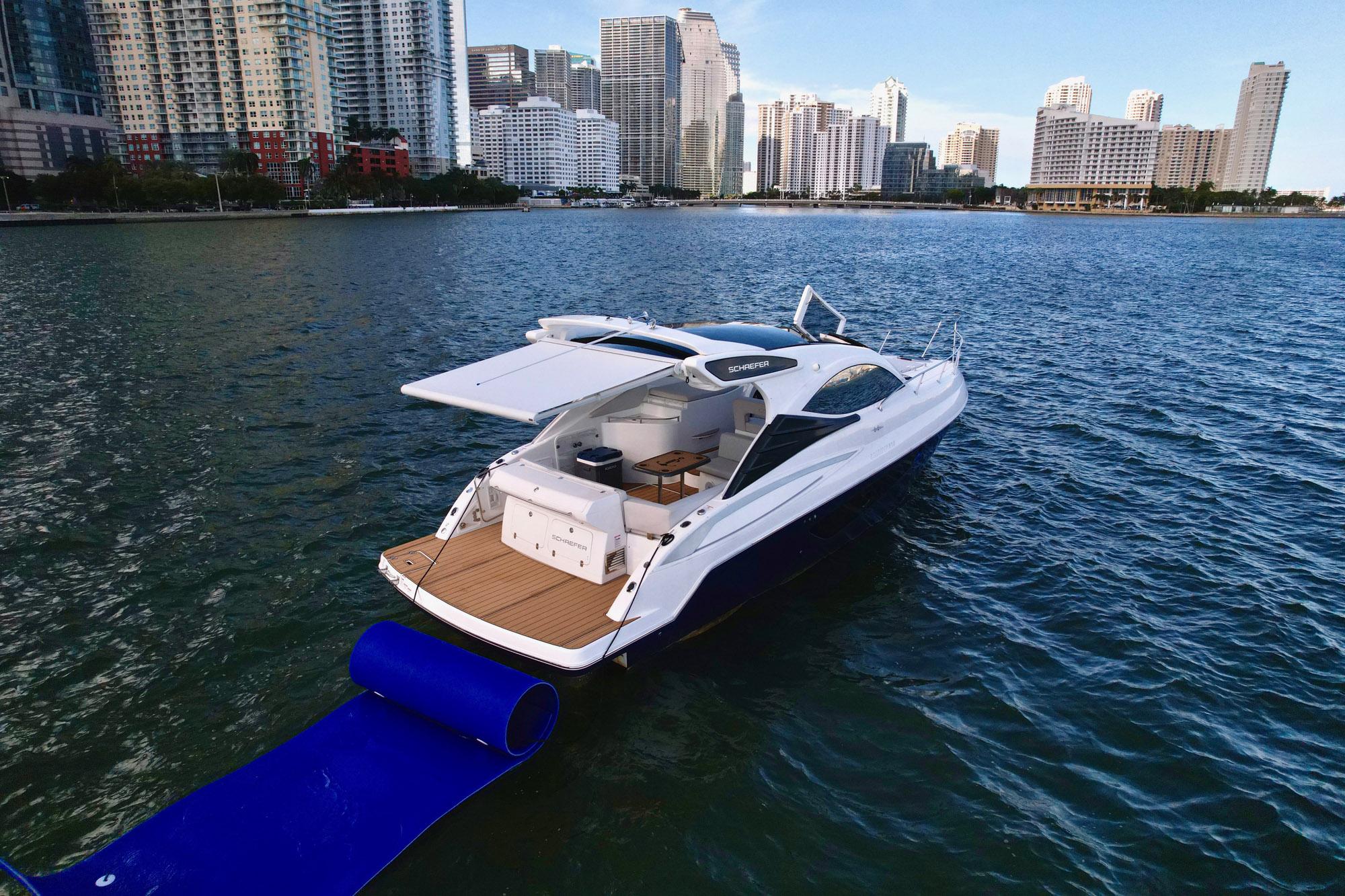 Luxury Schaefer 375 yacht on water, city skyline in background, 2023 model.