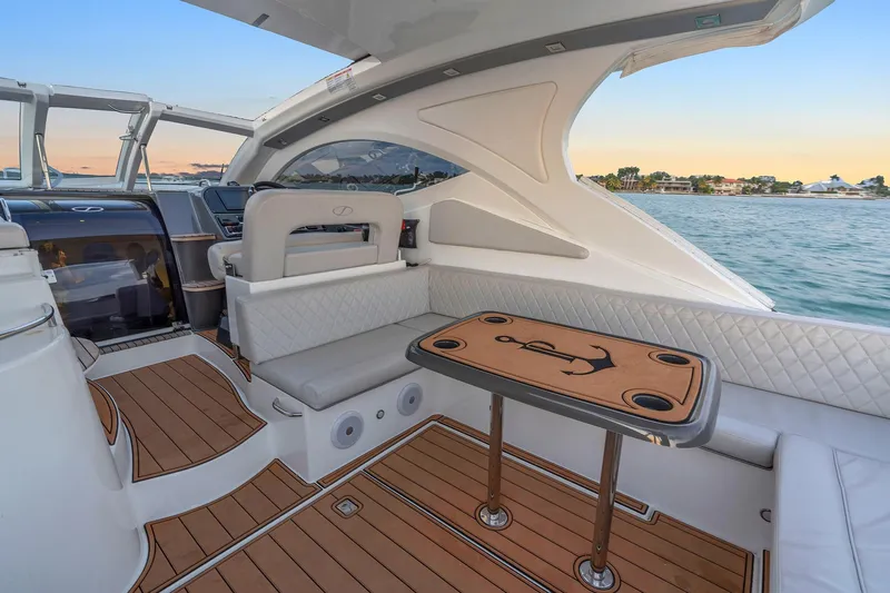 Dream Big Yacht Photos Pics Luxurious 2023 Schaefer 375 yacht interior with elegant seating and wooden table, overlooking serene waters.