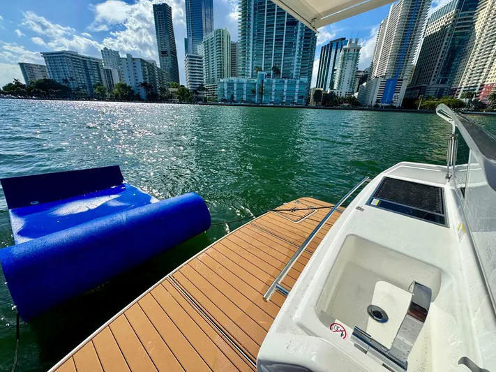 Dream Big Yacht Photos Pics 2023 Schaefer 375 yacht docked with city skyline and floating mat on water.