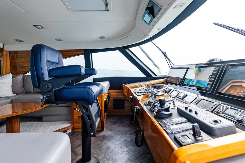 Backlash Yacht Photos Pics Luxurious helm of 2023 Viking 72 Enclosed Bridge yacht with advanced navigation systems.