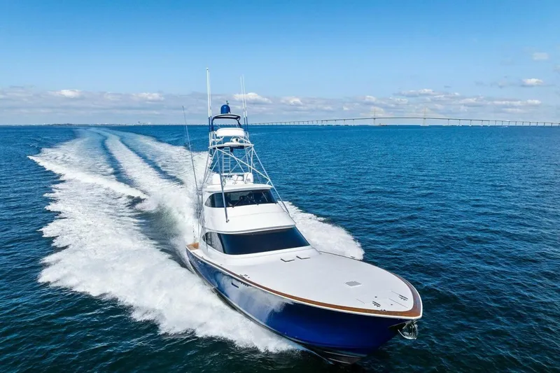 Backlash Yacht Photos Pics 2023 Viking 72 Enclosed Bridge yacht cruising on open water under clear skies.