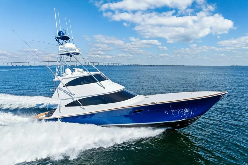 Backlash Yacht Photos Pics 2023 Viking 72 Enclosed Bridge yacht cruising on open water under a blue sky.