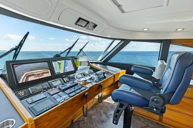 Backlash Yacht Photos Pics 2023 Viking 72 Enclosed Bridge helm with advanced navigation systems and ocean view.