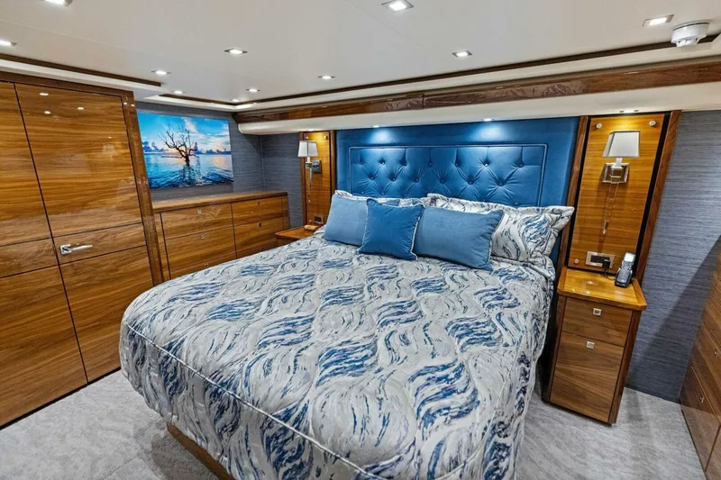 Backlash Yacht Photos Pics Luxurious bedroom interior of 2023 Viking 72 Enclosed Bridge yacht with elegant wood finishes.