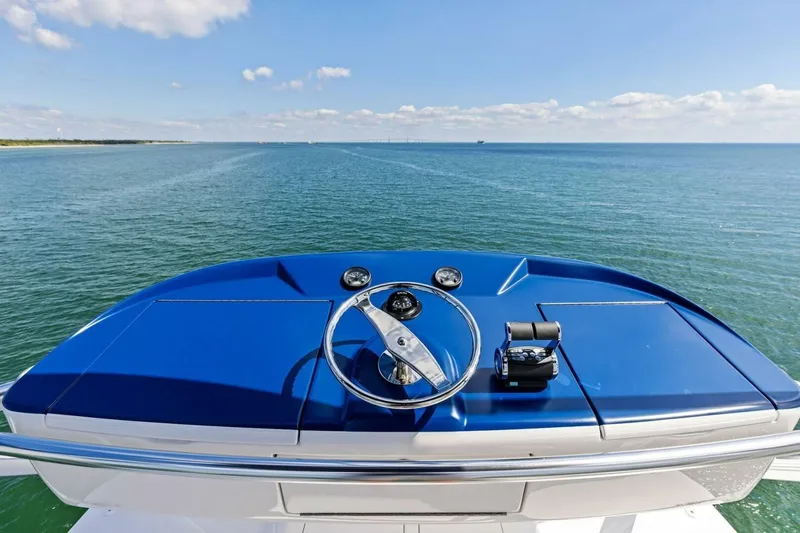 Backlash Yacht Photos Pics Steering wheel of 2023 Viking 72 Enclosed Bridge yacht overlooking the ocean.