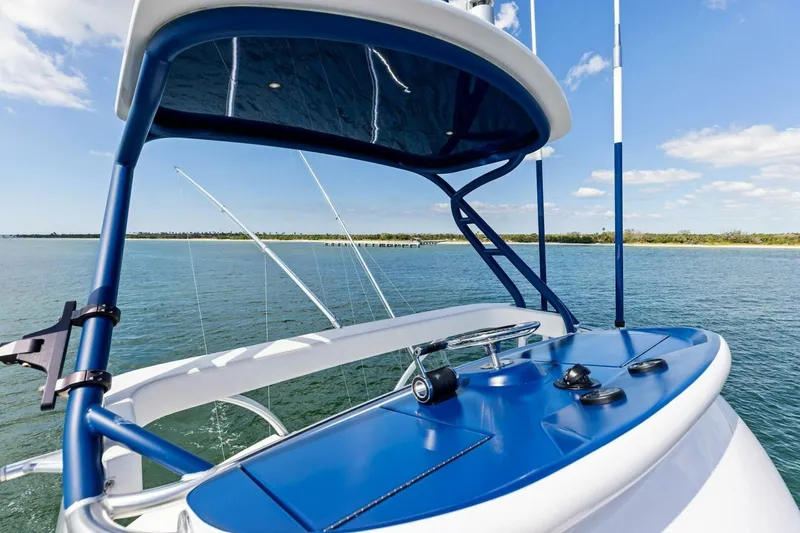 Backlash Yacht Photos Pics 2023 Viking 72 Enclosed Bridge yacht, blue helm, ocean view, clear sky.