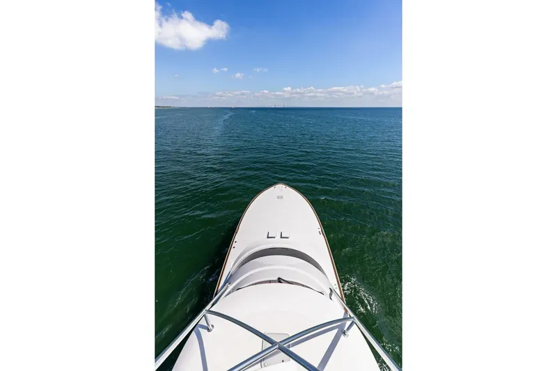 Backlash Yacht Photos Pics Bow view of 2023 Viking 72 Enclosed Bridge yacht on open sea.