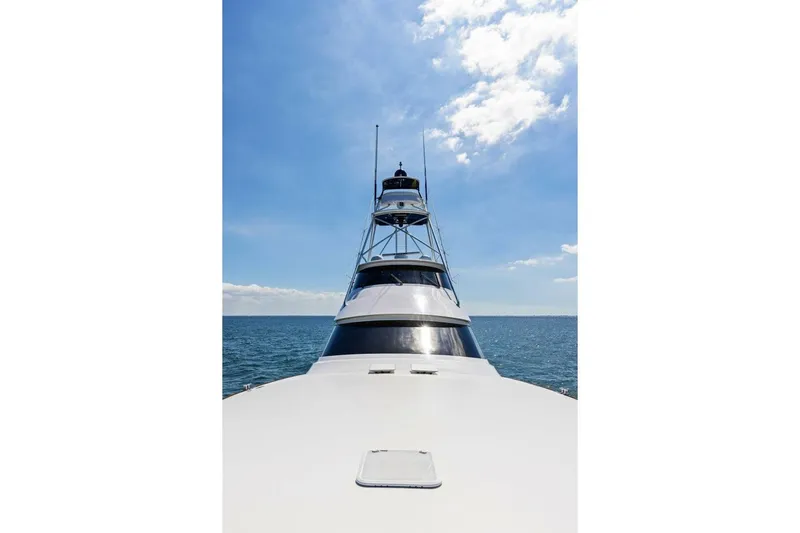 Backlash Yacht Photos Pics 2023 Viking 72 Enclosed Bridge yacht on open sea under clear blue sky.