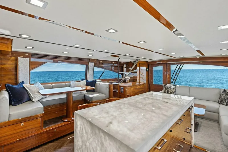 Backlash Yacht Photos Pics Luxurious interior of 2023 Viking 72 Enclosed Bridge yacht with ocean view.