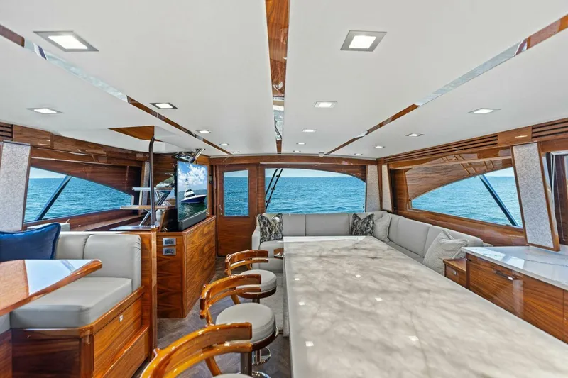 Backlash Yacht Photos Pics Luxurious interior of 2023 Viking 72 Enclosed Bridge yacht with ocean view.