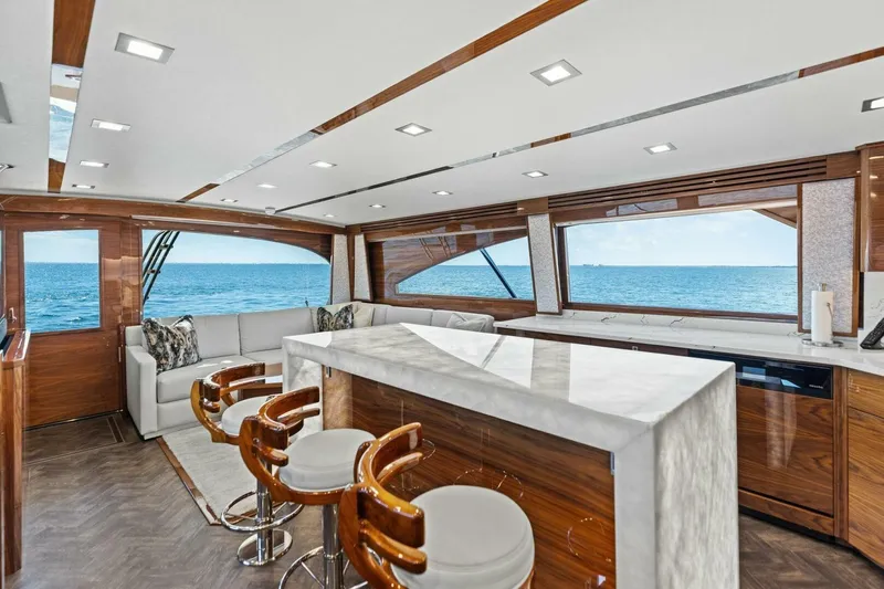 Backlash Yacht Photos Pics Luxurious interior of 2023 Viking 72 Enclosed Bridge yacht with ocean view.