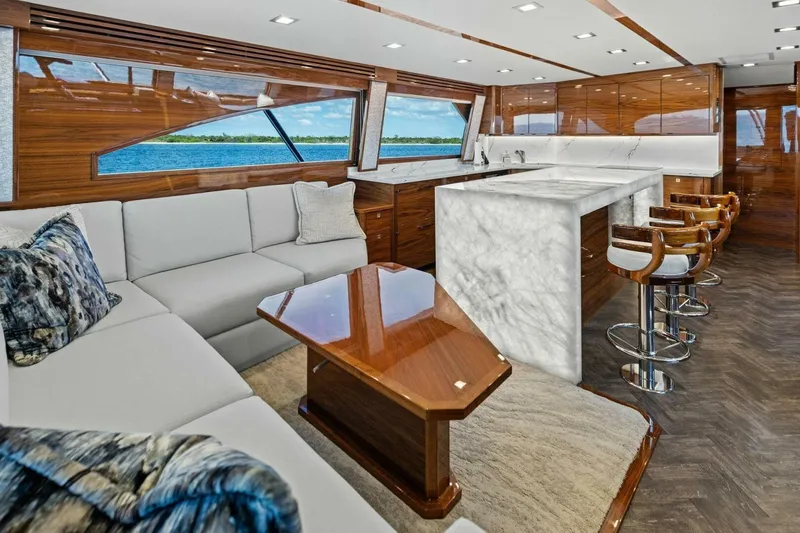Backlash Yacht Photos Pics Luxurious interior of 2023 Viking 72 Enclosed Bridge yacht with elegant seating and marble countertops.