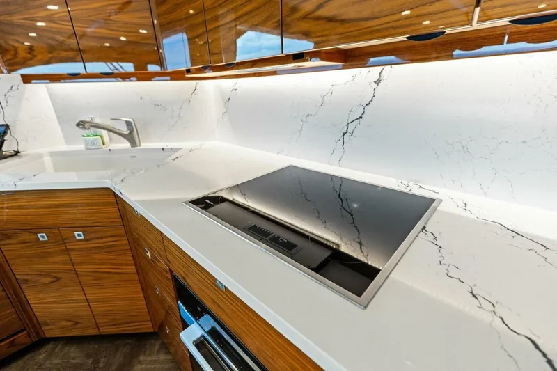 Backlash Yacht Photos Pics Luxurious kitchen in 2023 Viking 72 Enclosed Bridge yacht with marble countertops.