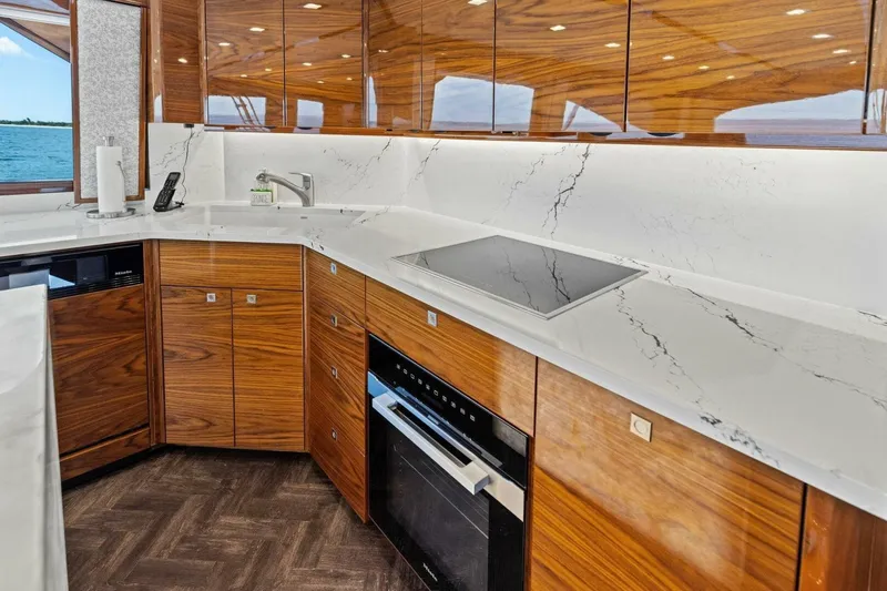 Backlash Yacht Photos Pics Luxurious kitchen interior of 2023 Viking 72 Enclosed Bridge yacht with marble countertops.