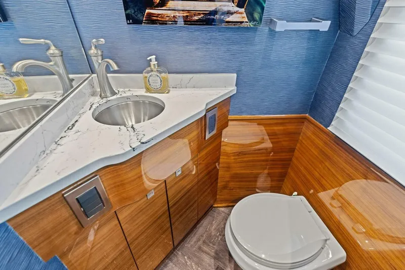 Backlash Yacht Photos Pics Luxurious bathroom in 2023 Viking 72 Enclosed Bridge yacht with marble countertop and modern fixtures.