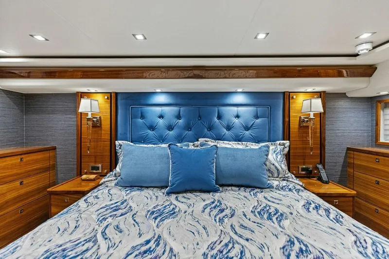 Backlash Yacht Photos Pics Luxurious bedroom interior of 2023 Viking 72 Enclosed Bridge yacht with blue accents.