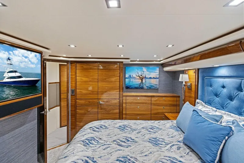 Backlash Yacht Photos Pics Luxurious 2023 Viking 72 Enclosed Bridge yacht bedroom with elegant wood finishes.