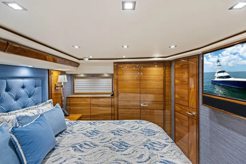 Backlash Yacht Photos Pics Luxurious interior of 2023 Viking 72 Enclosed Bridge yacht with elegant wood finishes and ocean view.