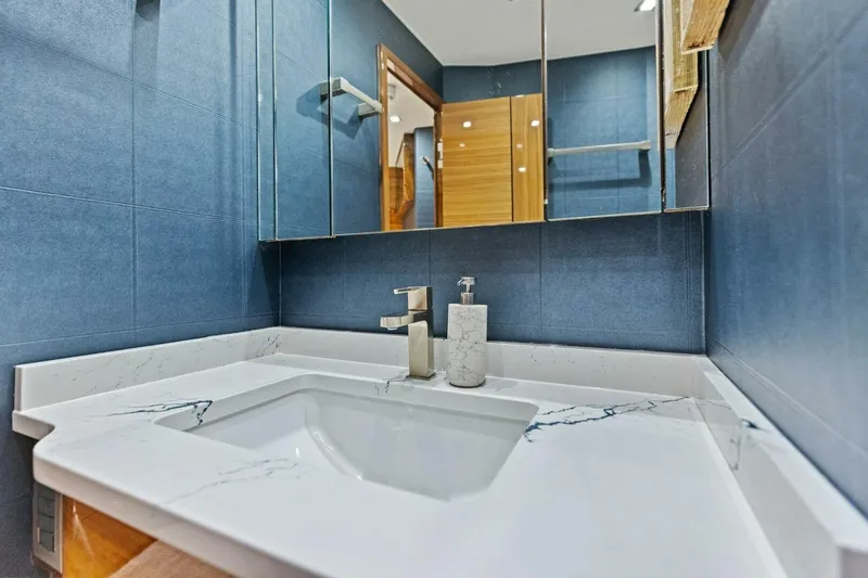 Backlash Yacht Photos Pics Luxurious bathroom in 2023 Viking 72 Enclosed Bridge yacht with marble countertop and modern fixtures.