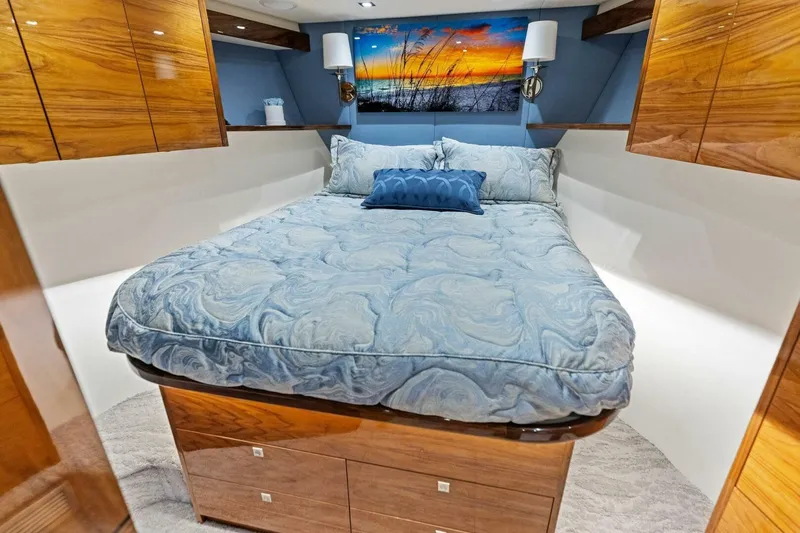 Backlash Yacht Photos Pics Luxurious bedroom interior of 2023 Viking 72 Enclosed Bridge yacht with elegant bedding and wood accents.