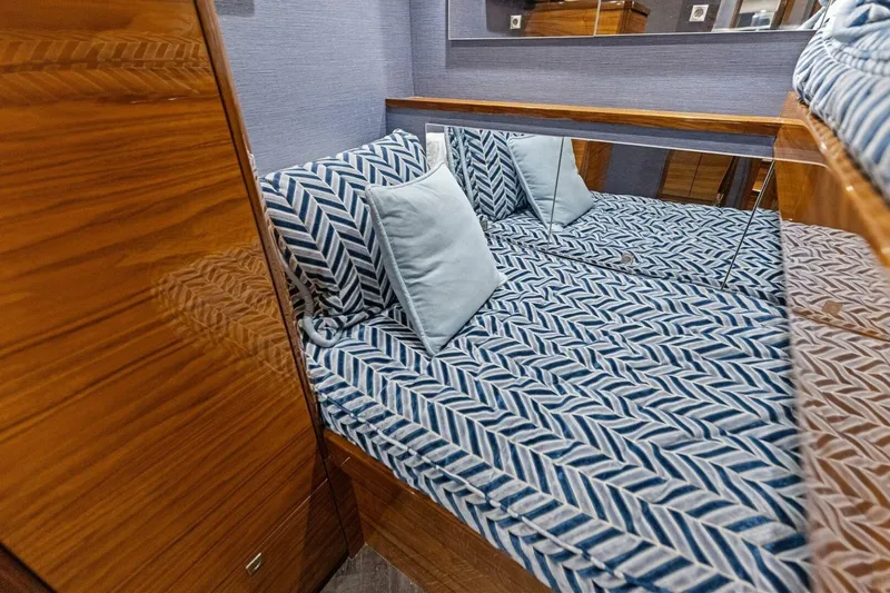 Backlash Yacht Photos Pics Luxurious cabin interior of 2023 Viking 72 Enclosed Bridge yacht with patterned bedding.