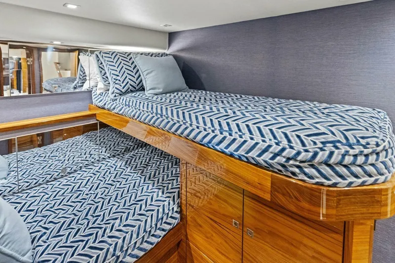 Backlash Yacht Photos Pics Luxurious cabin interior of 2023 Viking 72 Enclosed Bridge yacht with stylish bedding.