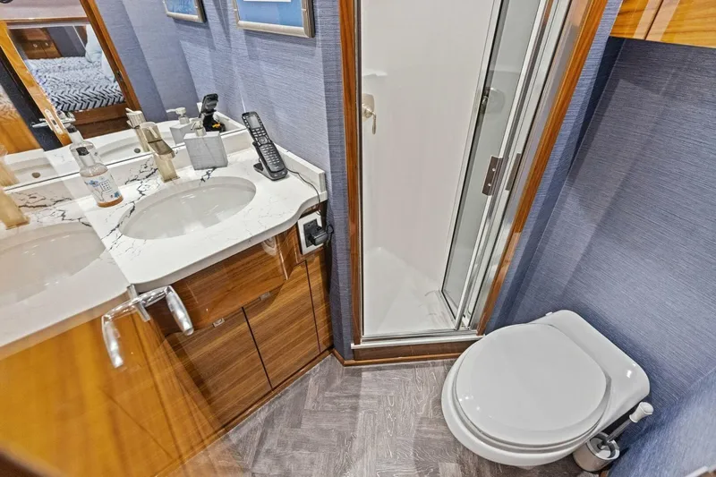 Backlash Yacht Photos Pics Luxurious bathroom in 2023 Viking 72 Enclosed Bridge yacht with modern fixtures and shower.