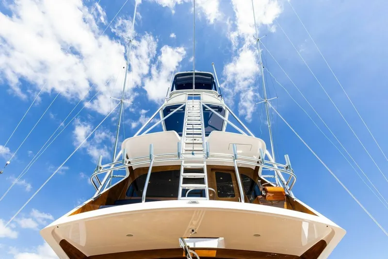 Backlash Yacht Photos Pics 2023 Viking 72 Enclosed Bridge yacht against a bright blue sky.