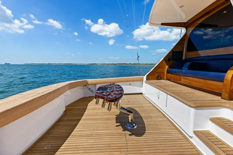 Backlash Yacht Photos Pics 2023 Viking 72 Enclosed Bridge yacht deck with ocean view and wooden seating.