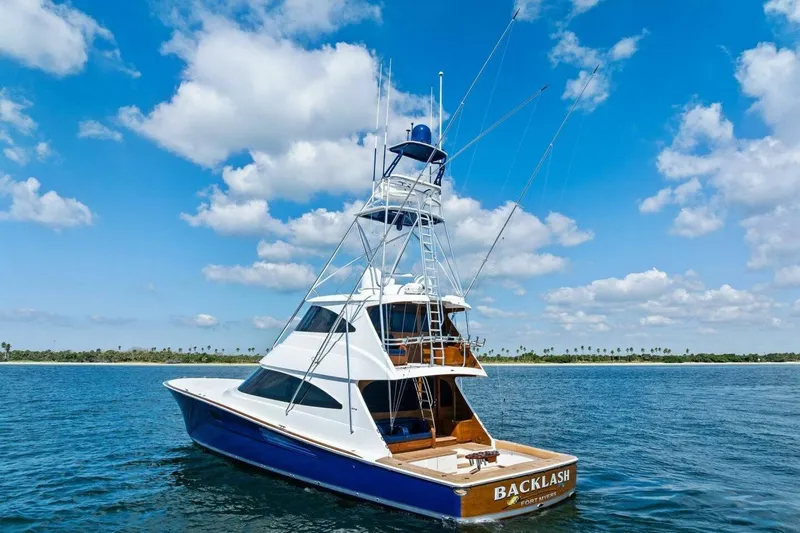 Backlash Yacht Photos Pics 2023 Viking 72 Enclosed Bridge yacht on open water under blue sky.