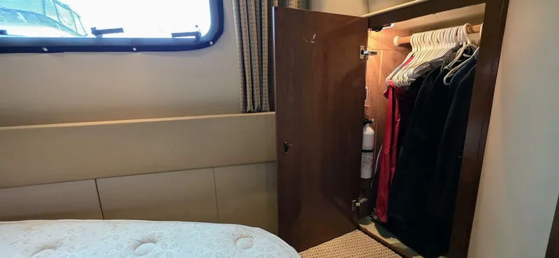  Yacht Photos Pics Closet interior on 2005 Meridian 368 Motor Yacht with hanging clothes and fire extinguisher.