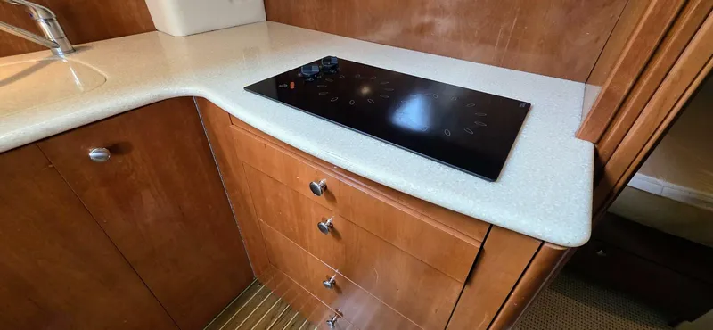  Yacht Photos Pics 2005 Meridian 368 Motor Yacht kitchen with sleek countertop and modern stovetop.
