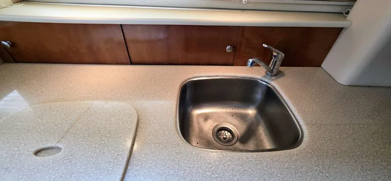  Yacht Photos Pics 2005 Meridian 368 Motor Yacht kitchen sink with countertop and wooden cabinets.