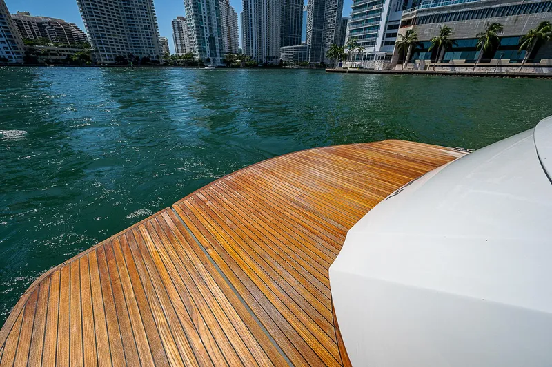 Scissortail II Yacht Photos Pics 2013 Pershing 92 Express yacht with wooden deck, city skyline in background.