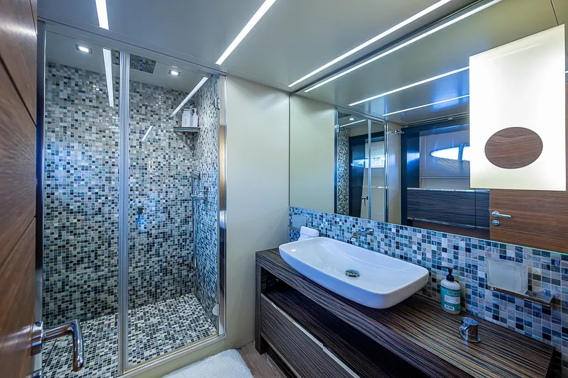 Scissortail II Yacht Photos Pics Luxurious bathroom on 2013 Pershing 92 Express yacht with modern sink and mosaic-tiled shower.
