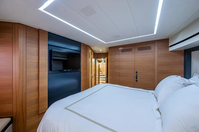 Scissortail II Yacht Photos Pics Luxurious bedroom interior of 2013 Pershing 92 Express yacht with modern wood paneling.