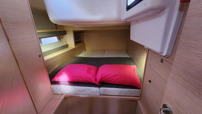 New Stock Boat - Available Now Yacht Photos Pics Cozy cabin interior of 2023 Dufour 530 yacht with pink pillows.