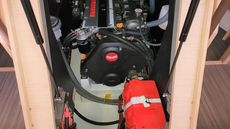 New Stock Boat - Available Now Yacht Photos Pics Engine compartment of 2023 Dufour 530 yacht, showcasing mechanical components and red equipment.