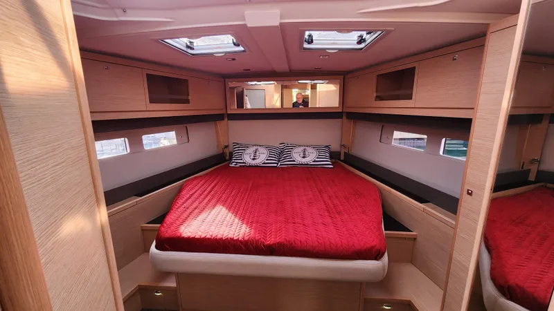 New Stock Boat - Available Now Yacht Photos Pics Luxurious cabin interior of 2023 Dufour 530 yacht with red bedding and modern design.
