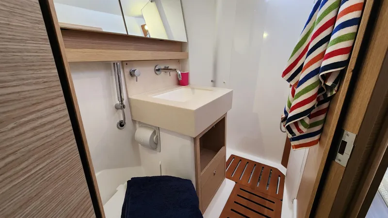 New Stock Boat - Available Now Yacht Photos Pics Modern bathroom in 2023 Dufour 530 yacht with sink, mirror, and colorful towel.