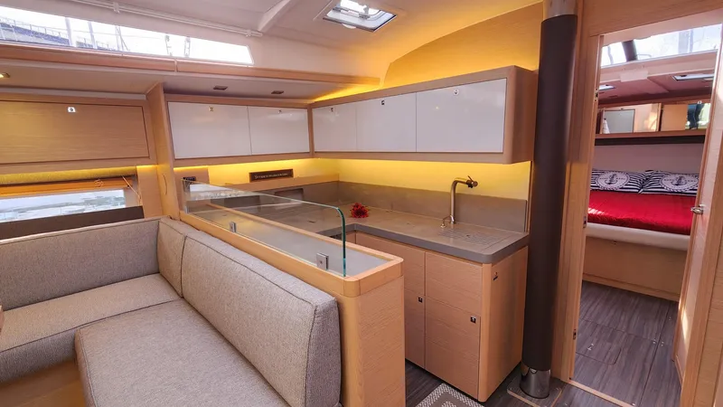 New Stock Boat - Available Now Yacht Photos Pics Modern interior of 2023 Dufour 530 yacht with sleek kitchen and cozy seating area.