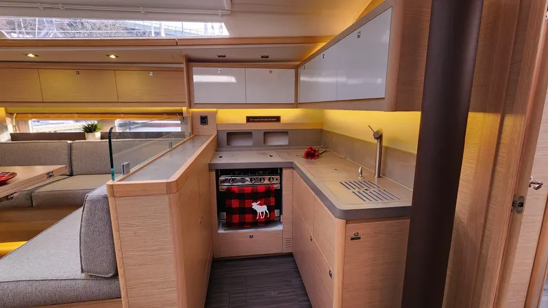 New Stock Boat - Available Now Yacht Photos Pics Modern kitchen interior of 2023 Dufour 530 yacht with sleek cabinetry and appliances.