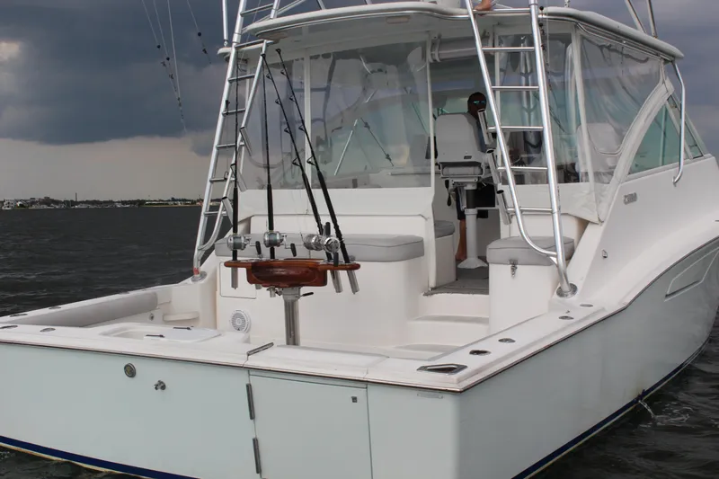  Yacht Photos Pics 2005 Cabo 40 Hardtop Express boat on water, featuring fishing rods and stormy sky.